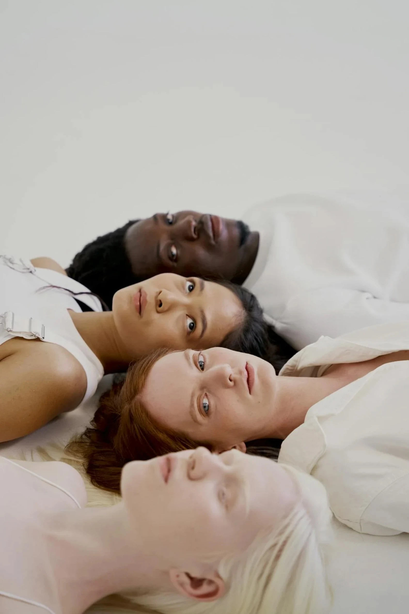 women-and-man-lying-on-white-surface-10211662